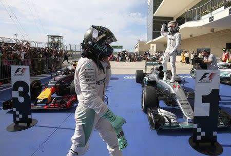 Formula One F1 - U.S. Grand Prix - Circuit of the Americas, Austin, Texas, U.S., 23/10/16. Mercedes' Lewis Hamilton of Britain celebrates his victory atop his car as teammate Nico Rosberg of Germany walks past. REUTERS/Adrees Latif