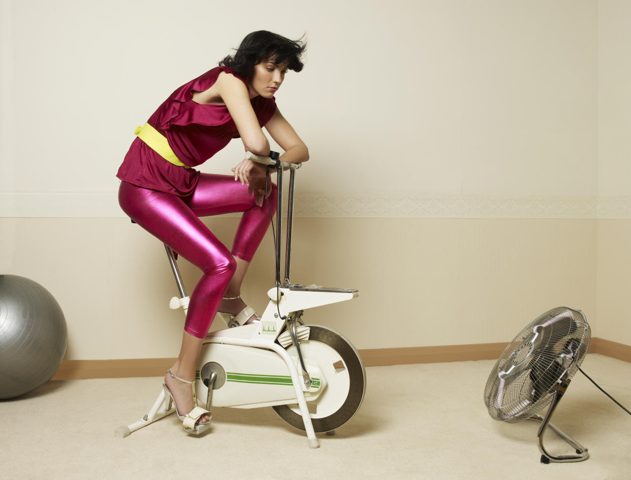 Young woman using exercising bike