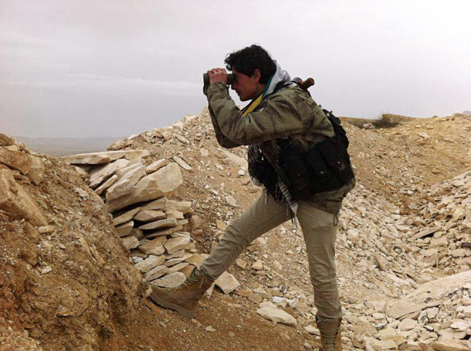 In this photo taken on Thursday, March 13, 2014, provided by the anti-government activist group Local Comity of Yabroud Town, which has been authenticated based on its contents and other AP reporting, a Syrian rebel looks through his binocular at one of the frontline of Yabroud town, the last rebel stronghold in Syria's mountainous Qalamoun region. Syria’s uprising, which began with largely peace protests in March 2011, has evolved into a civil war with sectarian overtones. Islamic extremists, including foreign fighters and Syrian rebels who have taken up hard-line al-Qaida-style ideologies, have played an increasingly prominent role among fighters, dampening the West’s support for the rebellion to overthrow Assad. (AP Photo/Local Comity of Yabroud Town)