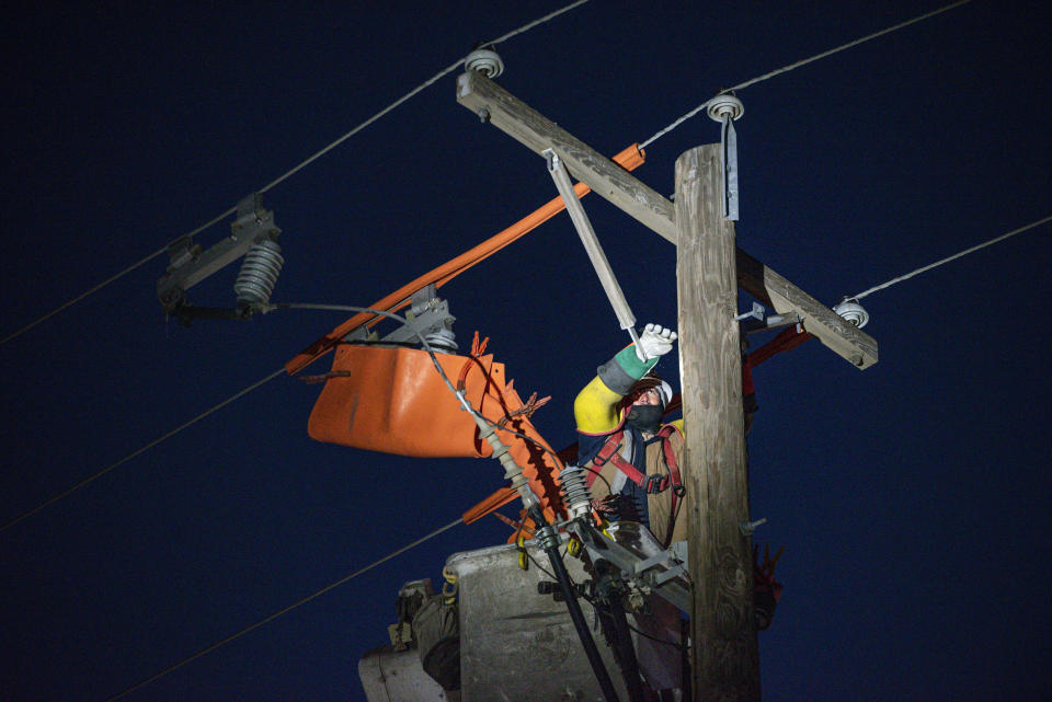 Oncor apprentice lineman Brendan Waldon repairs a utility pole that was damaged by the winter storm that passed through Texas Thursday, Feb. 18, 2021, in Odessa, Texas. (Eli Hartman/Odessa American via AP)