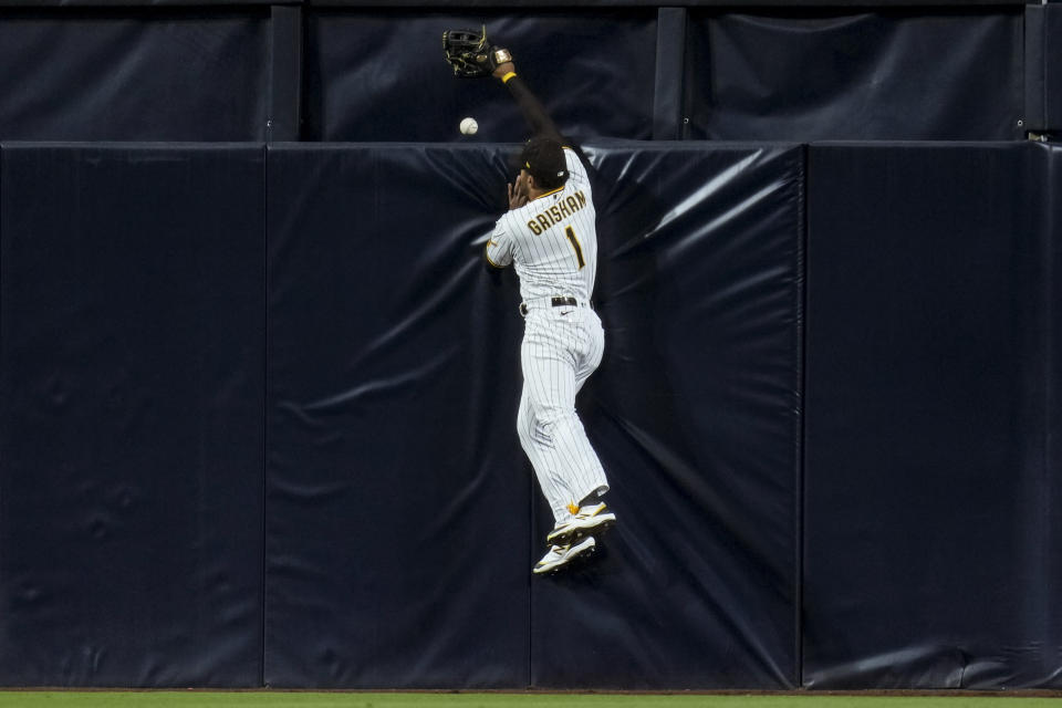 San Diego Padres center fielder Trent Grisham can't reach a three-run home run hit by Atlanta Braves' Ozzie Albies during the third inning of a baseball game Tuesday, April 18, 2023, in San Diego. (AP Photo/Gregory Bull)