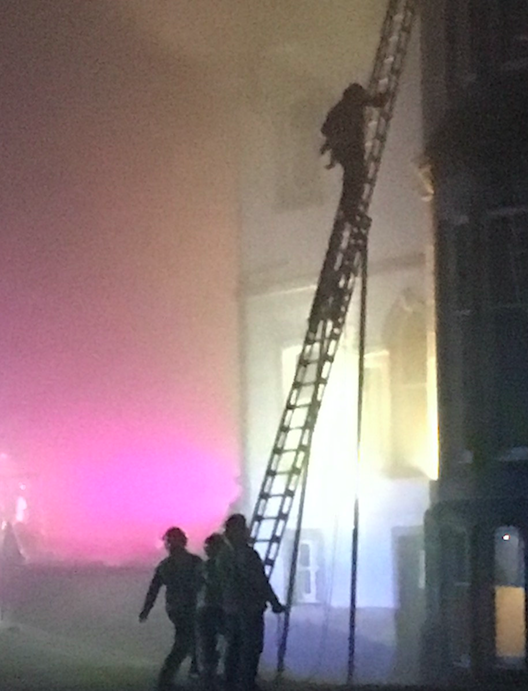 <em>The fireman carried the baby under his arms from the burning hotel (SWNS)</em>