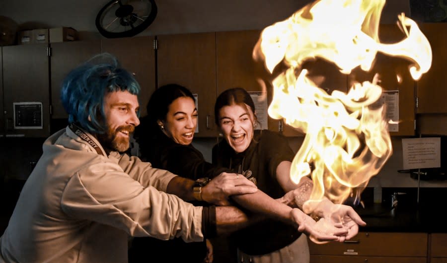 Lexi Arwine, right, and Kamdyn Carr react as thy have methane soap bubbles burst into fire in their hands Friday with the help of Garden City High School instructor Alessandro Mariconi at one of the activitis during the school’s Arts and Communications Academy showcase. The showcase highlighted the different departments within the academy. Arwine and Carr are GCHS juniors. BRAD NADING/GARDEN CITY TELEGRAM (Courtesy: Finney County Historical Society)