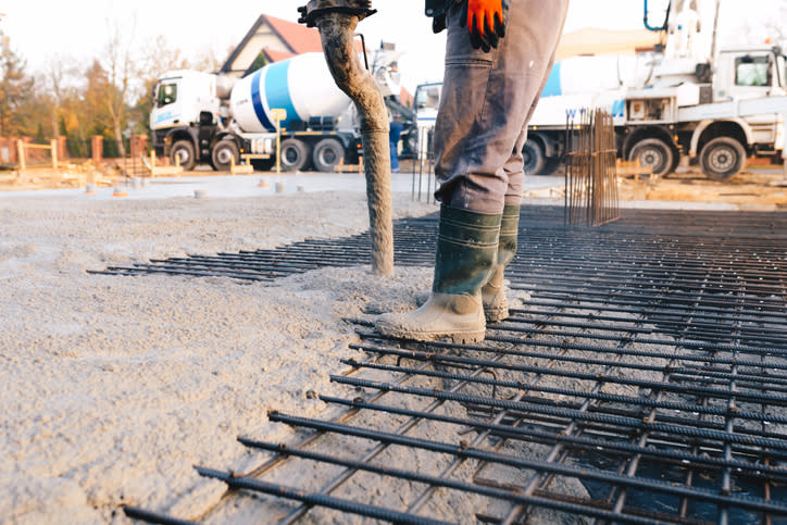 A worker guiding concrete into place.