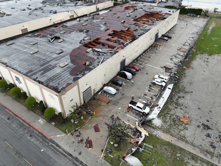 Montebello, CA - March 22: Crews start to clean up debris after a strong microburst -- which some witnesses dubbed a possible tornado -- which injured one person and heavily damaged several cars and buildings, including the roof of the Royal Paper Box Company, shown in photo, in Montebello Wednesday, March 22, 2023. Five buildings have been damaged and one has been red-tagged. Video from the scene showing portions of rooftops being ripped off industrial structures and debris swirling in the air. The National Weather Service on Tuesday night issued a brief tornado warning in southwestern Los Angeles County, but it was allowed to expire after about 15 minutes when weather conditions eased. There was no such warning in place late Wednesday morning when the powerful winds hit Montebello, near the area of Washington Boulevard and Vail Avenue. (Allen J. Schaben / Los Angeles Times)