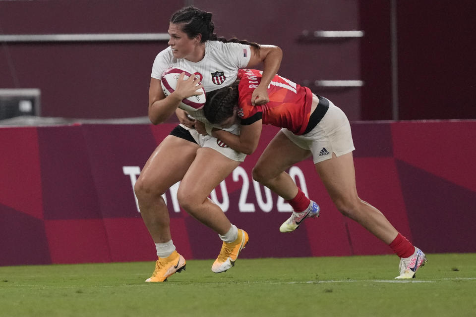 Ilona Maher of the United States is tackled by Britain's Helena Rowland in their women's rugby sevens quarterfinal match at the 2020 Summer Olympics, Friday, July 30, 2021 in Tokyo, Japan. (AP Photo/Shuji Kajiyama)