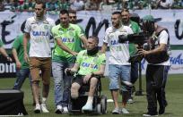 Chapecoense players Neto, left, goalkeeper Follmann, on the wheelchair, and Alan Ruschel, right, the three players that survived the air crash, arrive for an Sudamericana trophy award ceremony prior to a friendly match against Palmeiras, in Chapeco, Brazil, Saturday, Jan. 21, 2017. Almost two months after the air tragedy that killed 71 people, including 19 team players, Chapecoense plays at its Arena Conda stadium against the 2016 Brazilian champion Palmeiras. (AP Photo/Andre Penner)