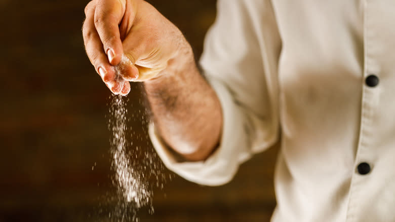 Chef sprinkling salt 