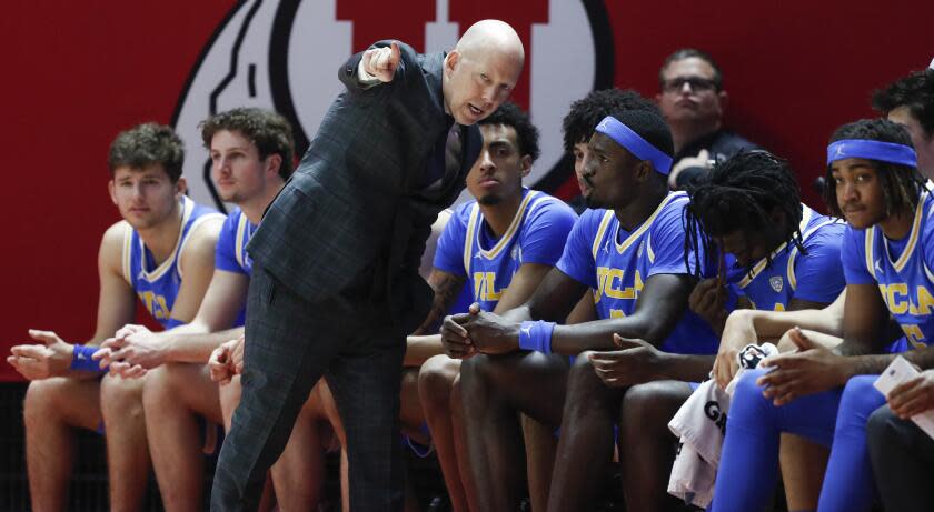 UCLA coach Mick Cronin talks to players on the bench during a game at Utah