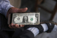 An Iranian street money exchanger holds a U.S. banknote in downtown Tehran, Iran, Monday, July 30, 2018. Iran's currency has dropped to a record low ahead of the imposition of renewed American sanctions, with many fearing prolonged economic suffering or possible civil unrest. (AP Photo/Vahid Salemi)