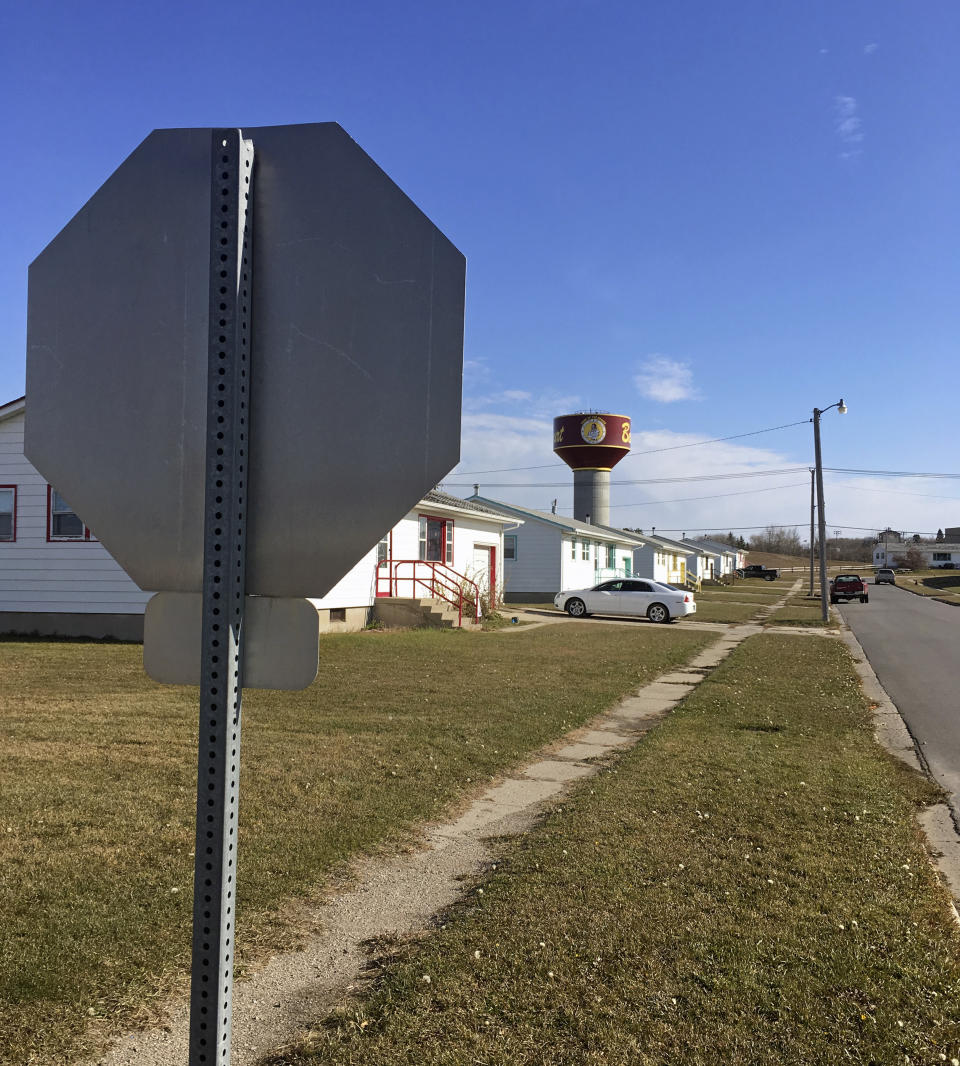 In this Wednesday, Oct. 24, 2018, photo, residential roads with no street name or number signs such as this one in Belcourt, N.D., are common on the Turtle Mountain Indian Reservation. Native Americans in North Dakota face a hurdle in getting identification with street addresses that will enable them to vote under recently tightened state rules. (AP Photo/Blake Nicholson)