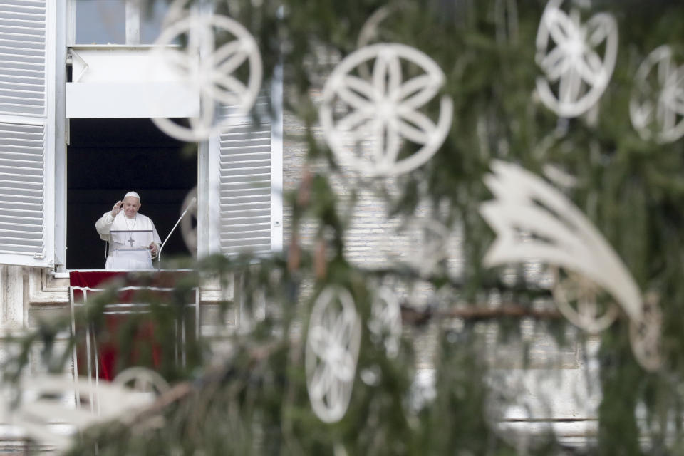 Pope Francis, framed by the Vatican Christmas tree, delivers his blessing as he recites the Angelus noon prayer from the window of his studio overlooking St.Peter's Square, on the Immaculate Conception day, at the Vatican, Tuesday, Dec. 8, 2020. (AP Photo/Andrew Medichini)