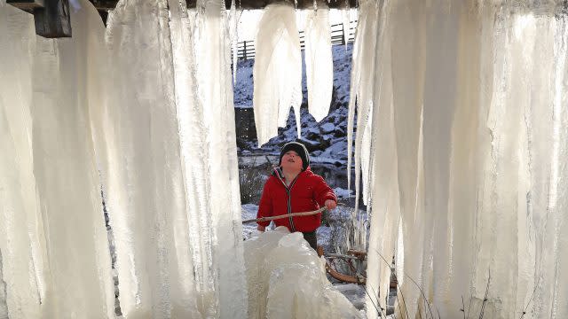 Three-year-old Reuben looks at a wall of icicles formed in County Durham (Owen Humphreys/PA)