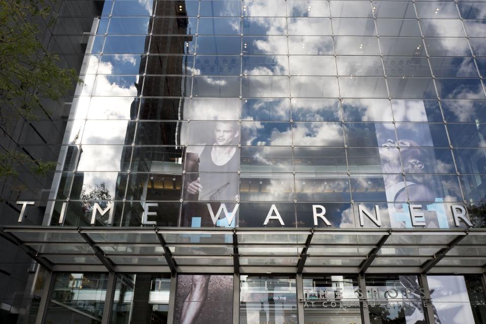 FILE - In this Monday, Oct. 24, 2016, file photo, clouds are reflected in the glass facade of the Time Warner building in New York. AT&T’s $85 billion purchase of Time Warner may be getting an easier path to approval after the chief telecommunications regulator says it isn’t likely to review the deal. (AP Photo/Mark Lennihan, File)