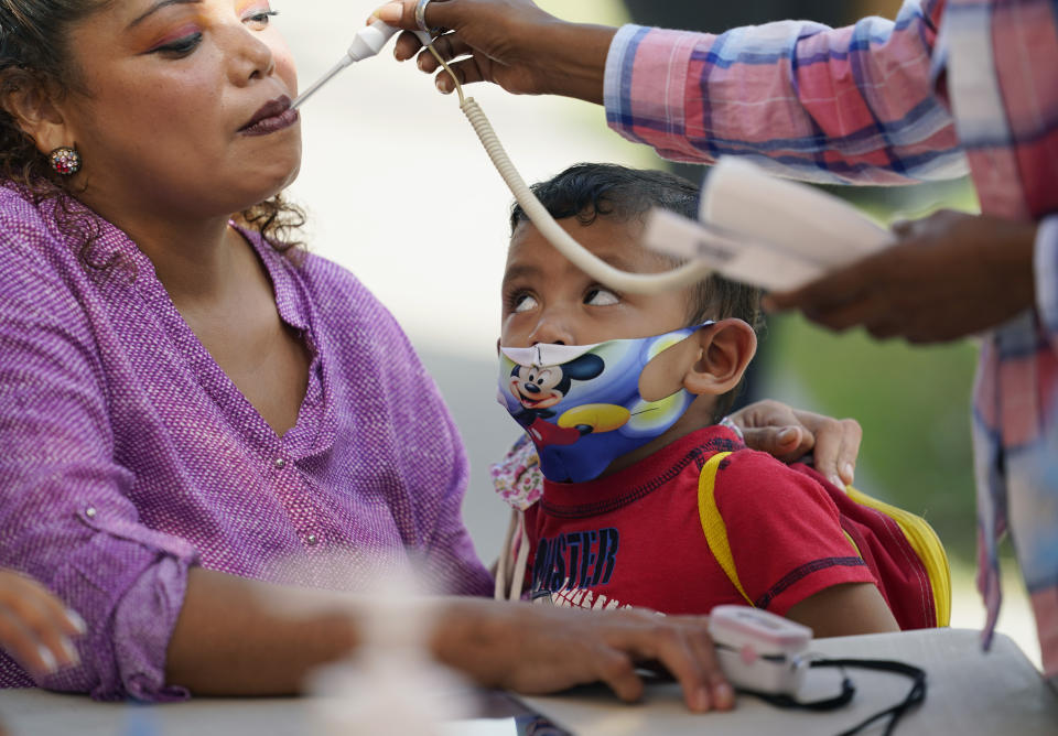 A woman seeking asylum in the U.S and waiting in Mexico, is tested at a clinic in Matamoros, Mexico, Nov. 17, 2020. A humanitarian organization led by U.S. military veterans has treated thousands of migrants over the past year at two clinics in a Mexican town across the border from Texas. But Global Response Management is attempting to go beyond mere crisis response and build a system to make it easier to track the health of migrants along their journey from Central America. (AP Photo/Eric Gay)