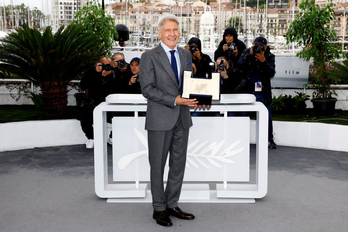 Harrison Ford poses with his honorary Palme d'Or Award at the 76th Cannes on 19 May 2023 (Reuters)
