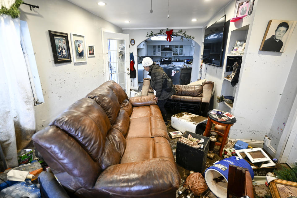 Homeowner Maria Ramirez walks through her home damaged by flooding Tuesday, Jan. 23, 2024, in San Diego. Ramirez' home was damaged when flood waters rushed though her home on Monday, Jan. 23, 2024. (AP Photo/Denis Poroy)