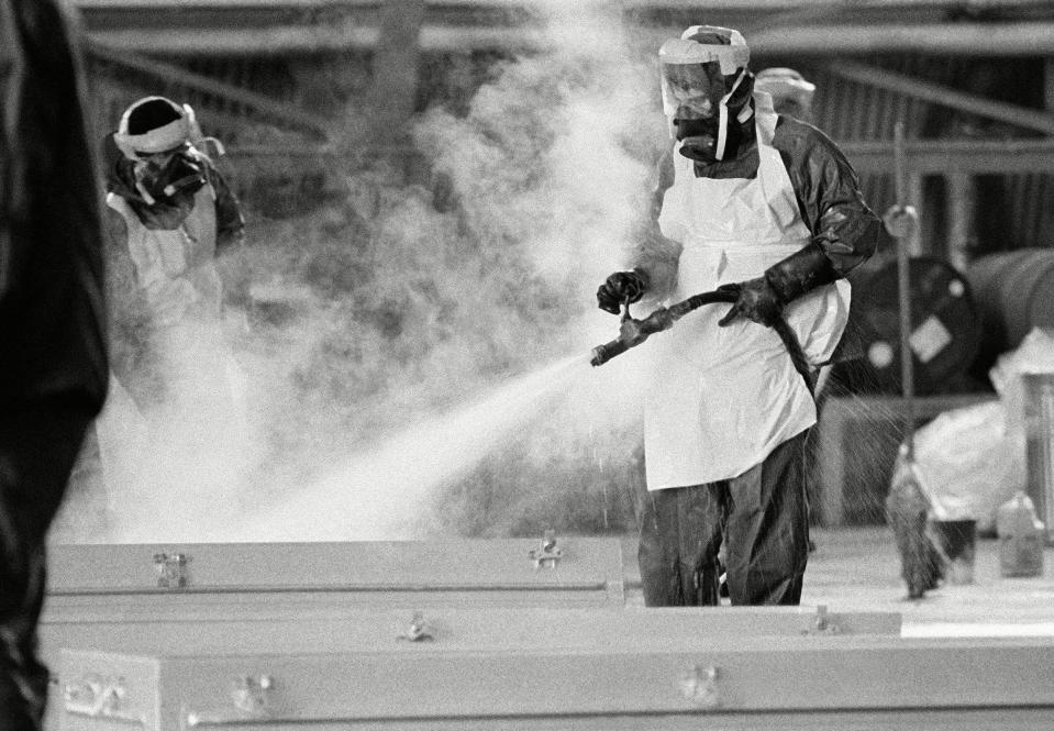 With more bodies being found at the Jonestown mass suicide scene in Guyana, the military is being asked to ship more caskets to bring the bodies back to the U.S. Here a volunteer airman uses steam mixed with chemicals to clean and disinfect a metal casket at Dover Air Force Base in Delaware, for reuse again in Guyana.