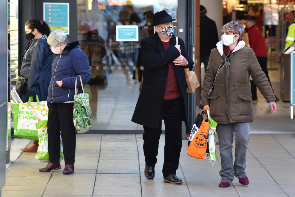 BASILDON, ENGLAND - DECEMBER 17: People wear face masks while out shopping on December 17, 2020 in Basildon, England. As Coronavirus cases continue to rise across the country, Basildon in Essex has the third-highest infection rate with 696.1 cases per 100,000 behind Swale and Medway, both in Kent.  (Photo by John Keeble/Getty Images)