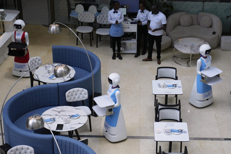 Robotic waiters stand at Robot Cafe in Nairobi, Kenya Thursday, Aug. 29, 2024. The three robots, christened Claire, R24 and Nadia, are not programmed to have a full conversation with customers, but they can say "Your order is ready, Welcome" then people have to press an exit button after picking up their food from the tray. (AP Photo/Brian Inganga)