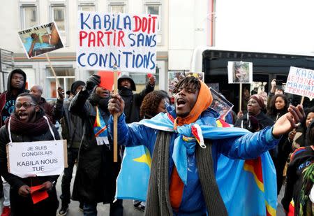 A demonstrator holds a sign reading "Kabila must leave without any conditions" during a protest against plans of Democratic Republic of Congo's President Joseph Kabila to stay in office past the end of his term, in central Brussels, Belgium, December 19, 2016. REUTERS/Francois Lenoir