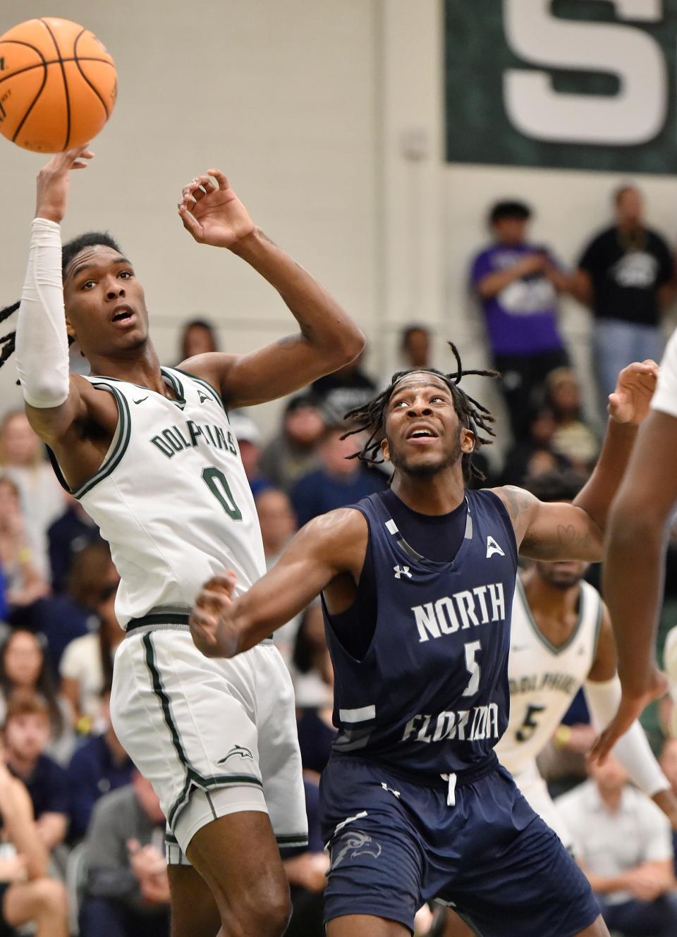 Jackson High graduate Stephon Payne III (0) of Jacksonville University and Dorian James (5) of the University of North Florida watch for the rebound of a missed shot during their game on Feb. 24 at Swisher Gym.