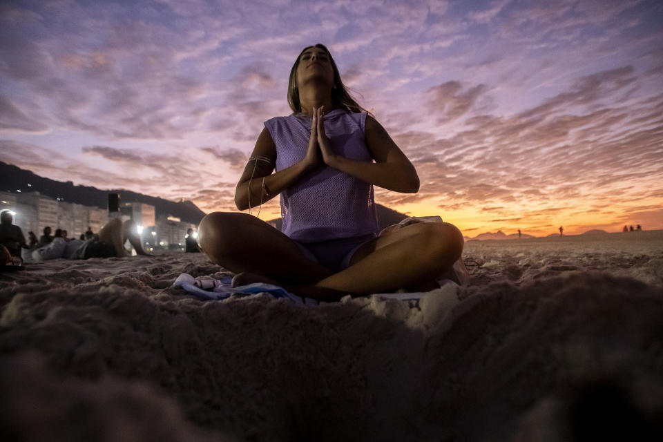 Una mujer se sienta en la postura del lotus durante el evento "Yoga al amanecer" en la playa de Copacabana, en Río de Janeiro, Brasil, el 22 de junio de 2024. La actividad celebra el Día Internacional del Yoga fijado por Naciones Unidas para el 21 de junio. (AP Foto/Bruna Prado)