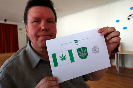 Designer Tonu Kukk holds a paper with a design of Kanepi municipality's flag and coat of arms featuring a cannabis leaf after the municipality council's vote in Polgaste, Estonia May 15, 2018. Kanep is the Estonian word for cannabis. Picture taken May 15, 2018. REUTERS/Ints Kalnins