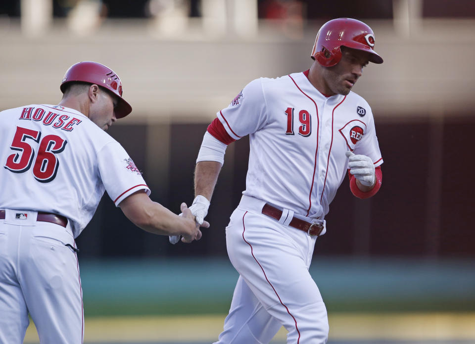 Cincinnati Reds' Joey Votto (19) is congratulated by third base coach J.R. House for his solo home run off Philadelphia Phillies starting pitcher Aaron Nola during the first inning of a baseball game Wednesday, Sept. 4, 2019, in Cincinnati. (AP Photo/Gary Landers)