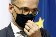 German Foreign Minister Heiko Maas adjusts his face mask after a meeting and a press conference with his Cyprus' counterpart Nicos Christodoulides at the foreign ministry house in divided Nicosia, Cyprus, Tuesday, Oct. 13, 2020. Maas is in Cyprus for a one-day visit. (AP Photo/Petros Karadjias)