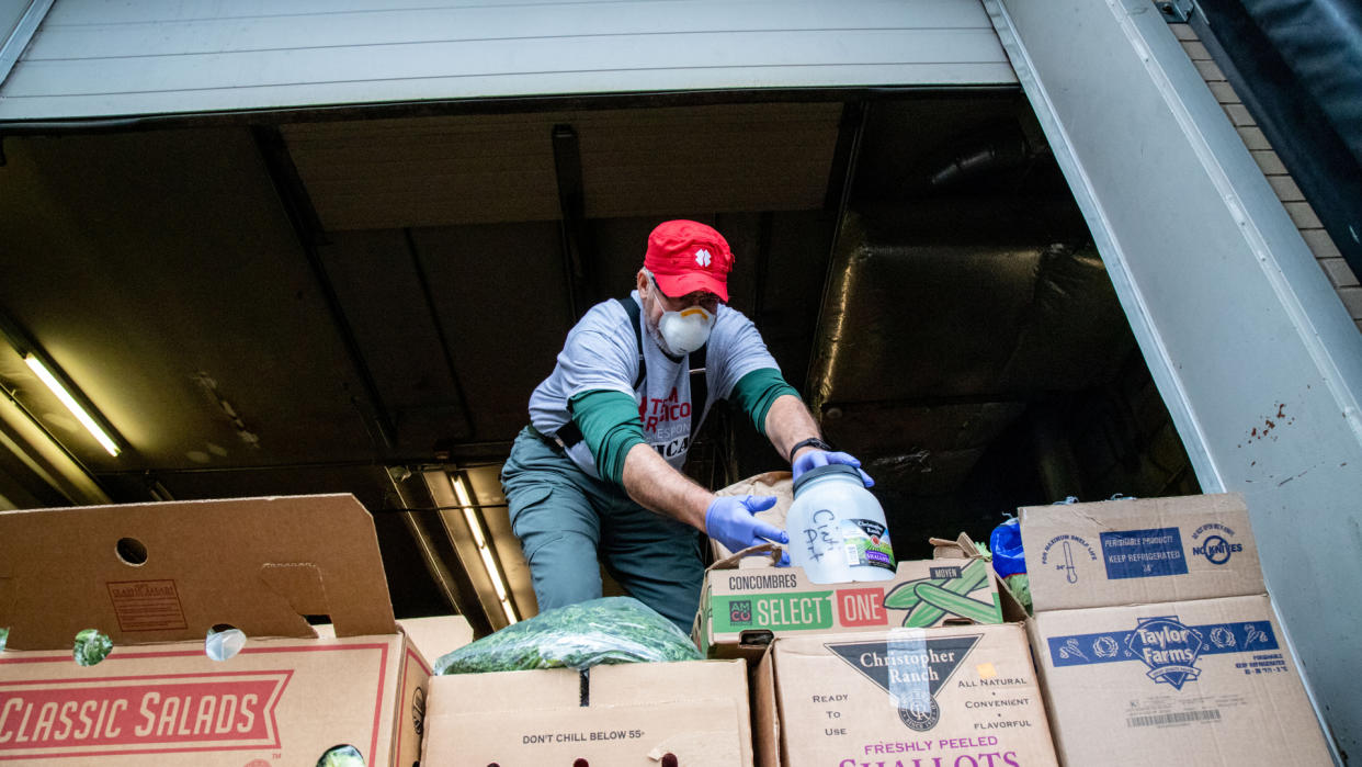 A volunteer helps transfer perishable food from the Cincinnati Art Museum to local food banks in the wake of the coronavirus pandemic, Thursday, March 19, 2020, in Cincinnati. (Photo by Jason Whitman)