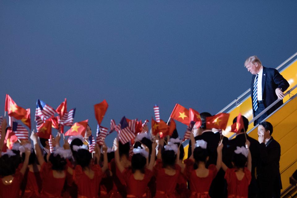 <p>President Donald Trump looks on a young girls wave U.S. and Vietnamese flags as he arrives in Hanoi on Nov. 11, 2017. Trump arrived in the Vietnamese capital after attending the Asia-Pacific Economic Cooperation (APEC) Summit leaders meetings earlier in the day in Danang. (Photo: Jim Watson/AFP/Getty Images) </p>