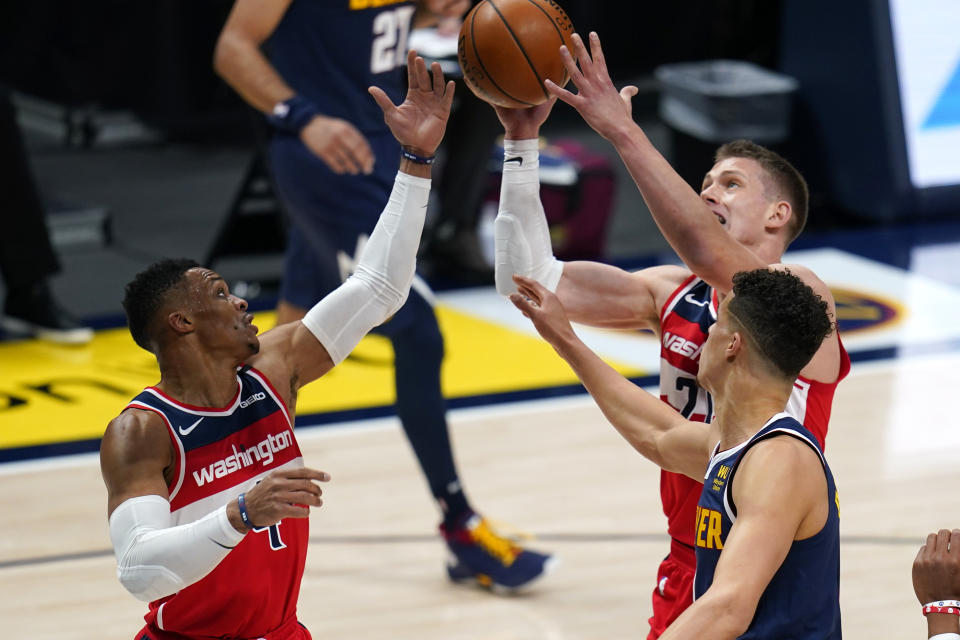 Washington Wizards' Moritz Wagner (21) and Russell Westbrook (4) and Denver Nuggets forward Michael Porter Jr. (1) go after a rebound during the first quarter of an NBA basketball game Thursday, Feb. 25, 2021, in Denver. (AP Photo/Jack Dempsey)
