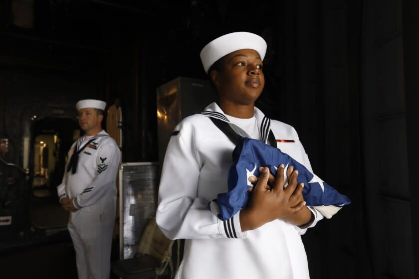 San Pedro, California-May 26, 2022-On board the USS Essex, U.S. Navy Operational Specialist Petty Officer 2nd class La'Tansia Smith, holds a pennant flag before morning colors on May 26, 2022. Smith, age 30, has three children and is based in San Diego, California. LA Fleet Week has returned to San Pedro, California at the Port of Los Angeles after a two-year absence due to the pandemic. Active-duty sailors and Marines are in town for community events. (Carolyn Cole / Los Angeles Times)