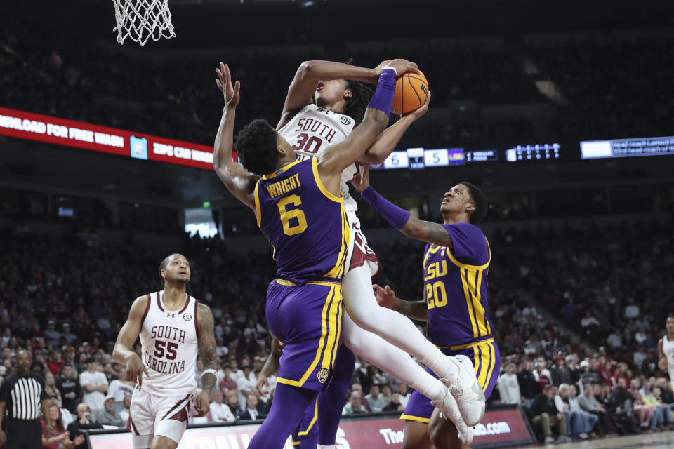 LSU guard Jordan Wright (6) forces a jump ball against South Carolina forward Collin Murray-Boyles (30) during the first half of an NCAA college basketball game Saturday, Feb. 17, 2024, in Columbia, S.C. (AP Photo/Artie Walker Jr.)