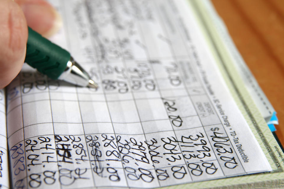 A person writing in their checkbook