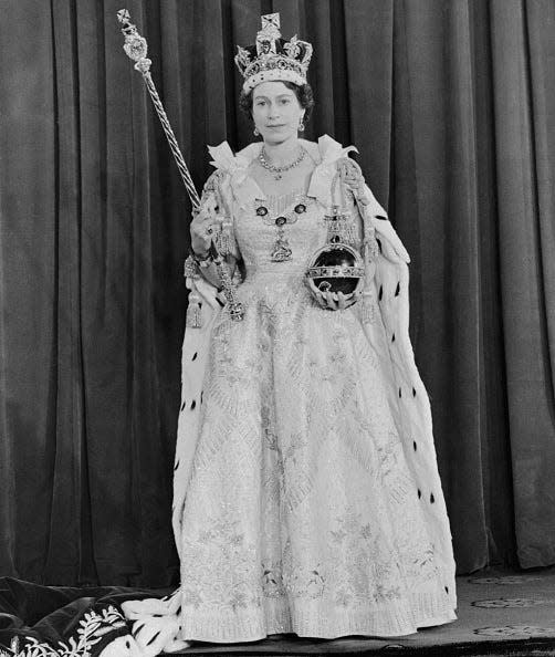 The queen in her dress, holding the orb and sceptre.