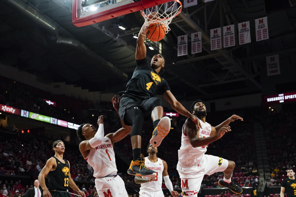 UMBC forward Tra'Von Fagan (4) dunks as Maryland guard Jahmir Young (1) and forward Donta Scott (24) defend during the first half of an NCAA college basketball game Thursday, Dec. 29, 2022, in College Park, Md. (AP Photo/Jess Rapfogel)