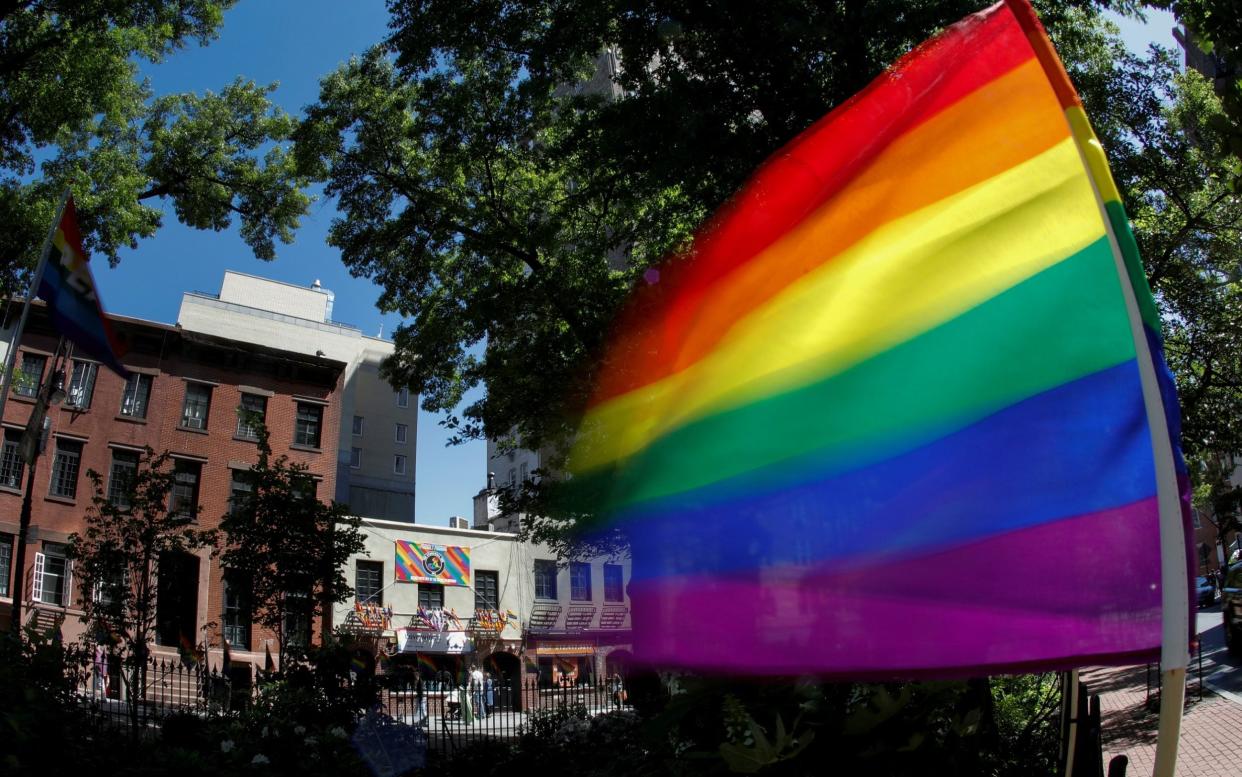 A rainbow flag waves in the wind at the Stonewall National Monument outside the Stonewall Inn in New York - Mike Segar/Reuters