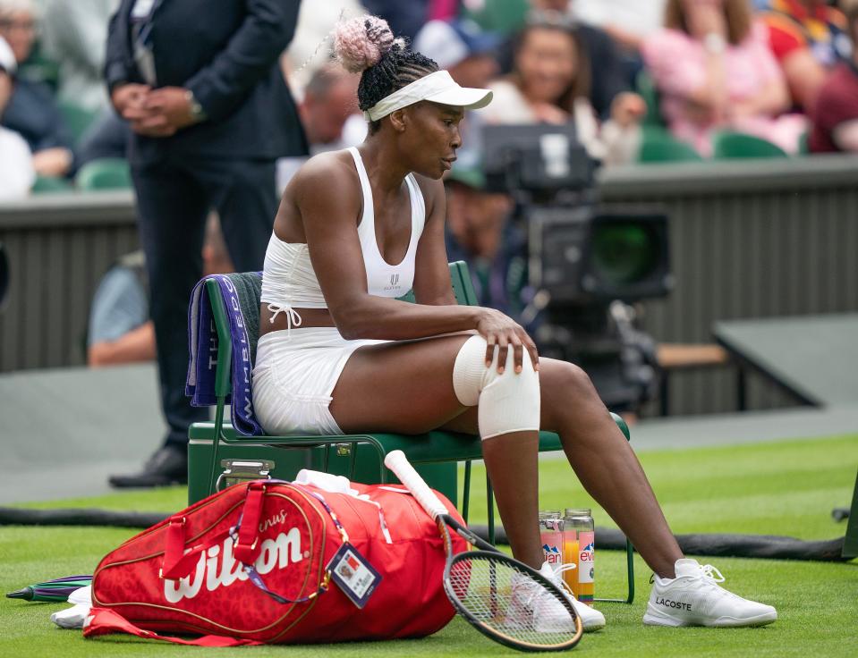 Venus Williams puts her hand on her injured knee during a change of ends in her first-round match against Elina Svitolina at Wimbledon.