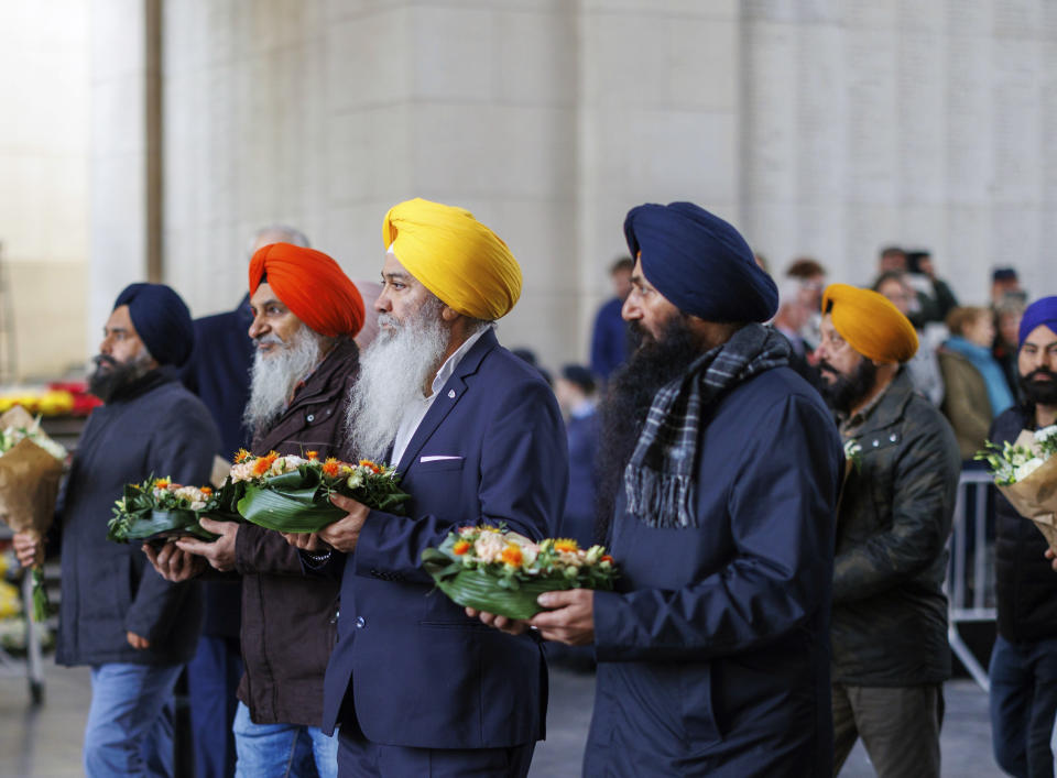 Participants from India prepare to lay wreaths during an Armistice Day ceremony at the Menin Gate Memorial to the Missing in Ypres, Belgium, Friday, Nov. 11, 2022. Since the end of World War I in 1918, millions of visitors, from as far away as the U.S., New Zealand, and South Africa, have flocked to memorials in northern France and Belgium to pay tribute to the fallen. (AP Photo/Olivier Matthys)