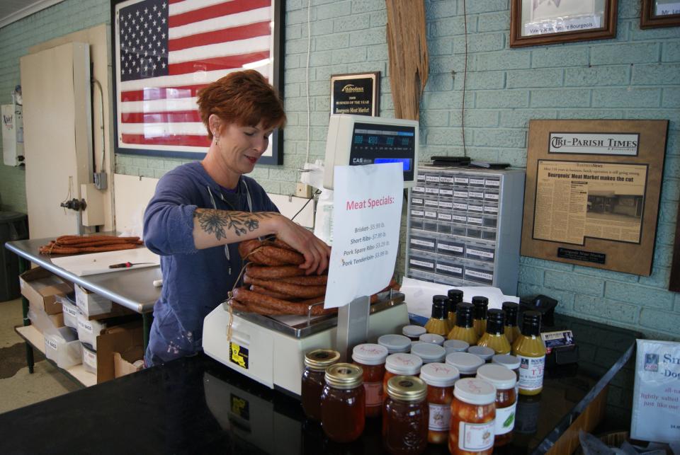 Stacey Jennings, 49, a butcher, weighs smoked sausage Wednesday at Bourgeois Meat Market in Schriever.