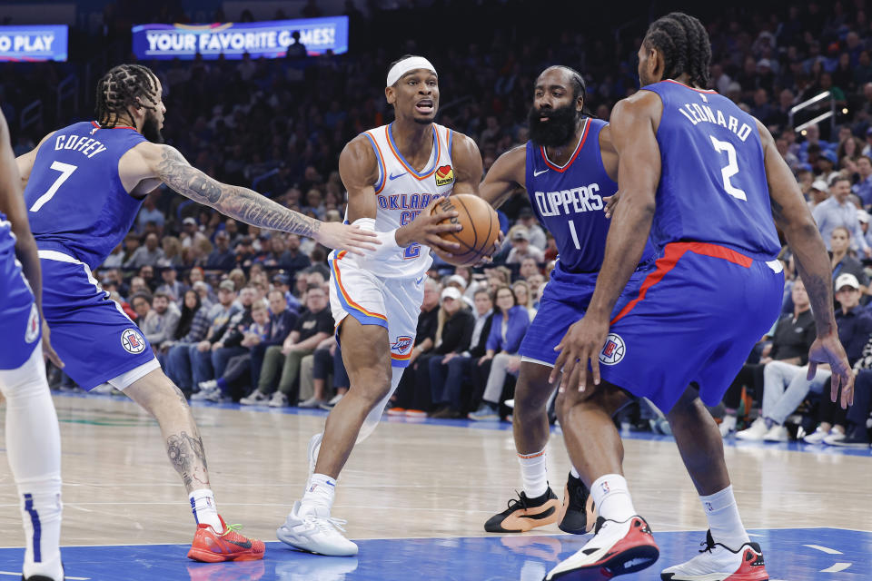 Feb 22, 2024; Oklahoma City, Oklahoma, USA; Oklahoma City Thunder guard Shai Gilgeous-Alexander (2) drives to the basket between LA Clippers guard James Harden (1) and guard Amir Coffey (7) during the second quarter at Paycom Center. Mandatory Credit: Alonzo Adams-USA TODAY Sports