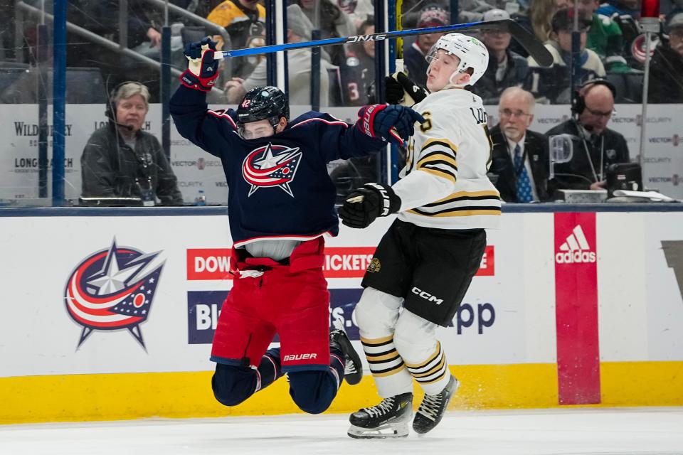 Jan 2, 2024; Columbus, Ohio, USA; Columbus Blue Jackets center Alexandre Texier (42) gets held by Boston Bruins defenseman Mason Lohrei (6) during the first period of the NHL hockey game at Nationwide Arena. Lohrei was penalized for the foul and Texier was given two minutes for embelishment.