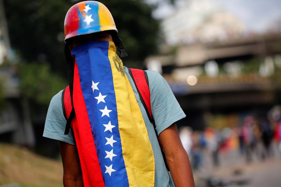 <p>An opposition supporter looks on during a blockade in an avenue while rallying against President Nicolas Maduro in Caracas, Venezuela, May 15, 2017. (Carlos Garcia Rawlins/Reuters) </p>