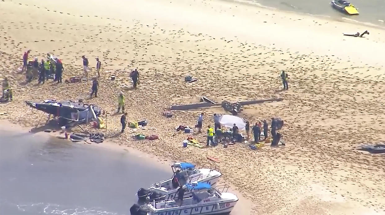 This image made from a video shows sand island with crashed helicopter, victims and emergency services on Gold Coast, Australia Monday, Jan. 2, 2023. Two helicopters collided in the Australian tourist hotspot Monday afternoon. (CH9 via AP)