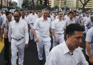 Singapore's People's Action Party (PAP) secretary-general Lee Hsien Loong crosses a street with his supporters to submit his papers during nomination day, ahead of the general elections in Singapore September 1, 2015. REUTERS/Edgar Su