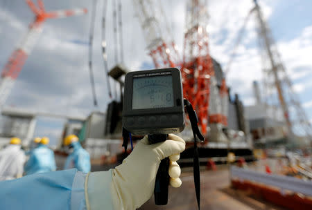 A geiger counter measures a radiation level of 54.0 microsievert per hour near the No.2 and No.3 reactor buildings at Tokyo Electric Power Co's (TEPCO) tsunami-crippled Fukushima Daiichi nuclear power plant in Okuma town, Fukushima prefecture, Japan February 18, 2019. Picture taken February 18, 2019. REUTERS/Issei Kato