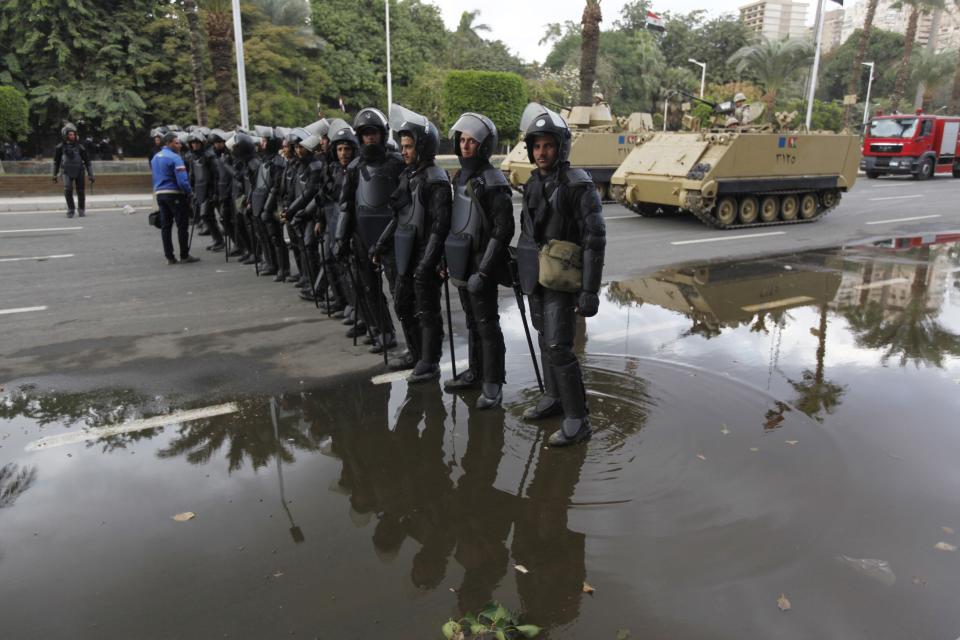 Egyptian security forces and army vehicles hold their positions outside Cairo university during clashes between riot policemen and Cairo University students, who are supporters of the Muslim Brotherhood and ousted Egyptian President Mohamed Mursi, in Cairo December 11, 2013. (REUTERS/Mohamed Abd El Ghany)