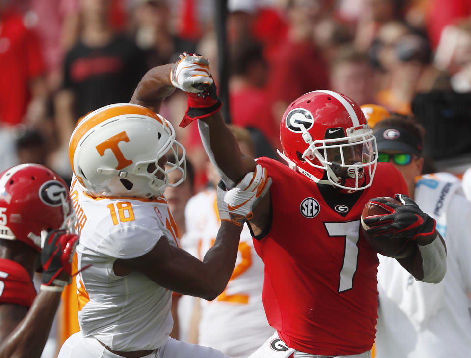 Georgia running back D'Andre Swift (7) fights off Tennessee defensive back Nigel Warrior (18) as he runs during the first half of an NCAA college football game Saturday, Sept. 29, 2018, in Athens, Ga. AP Photo/John Bazemore)